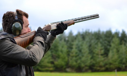 Canva man shooting shotguns at clay pigeon outdoors