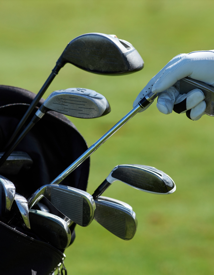 Gloved hand reaching for golf club