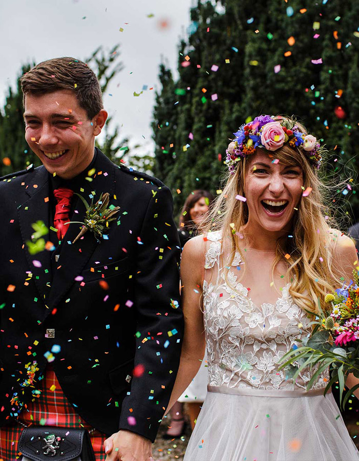 A bride and groom having confetti throw at them at their wedding at Glen Clova Hotel. Photography by Barry Robb Photography. https://barryrobbphotography.com/