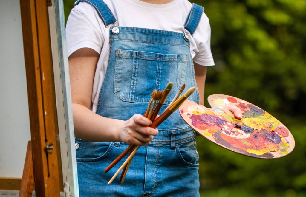 Woman at easel with paint and brushes