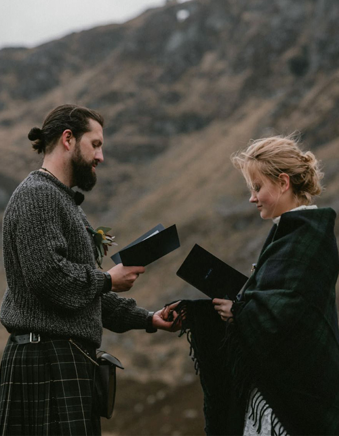 A bride and groom taking their vows at the foot of a mountain in Glen Clova. Photography by The Caryls. https://thecaryls.co.uk/