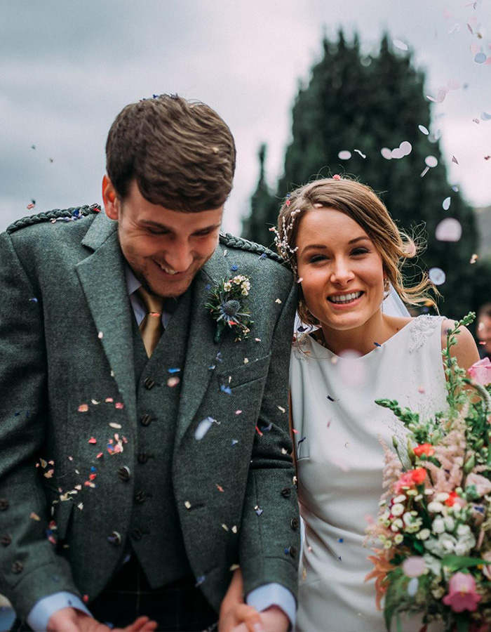 A bride and groom having confetti throw at them at their wedding at Glen Clova Hotel. Photography by Burfly Photography. https://burfly.co.uk/