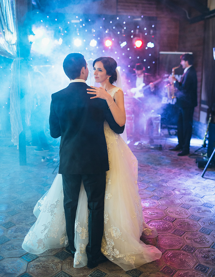 A bride and groom having the first dance with the wedding band in the background