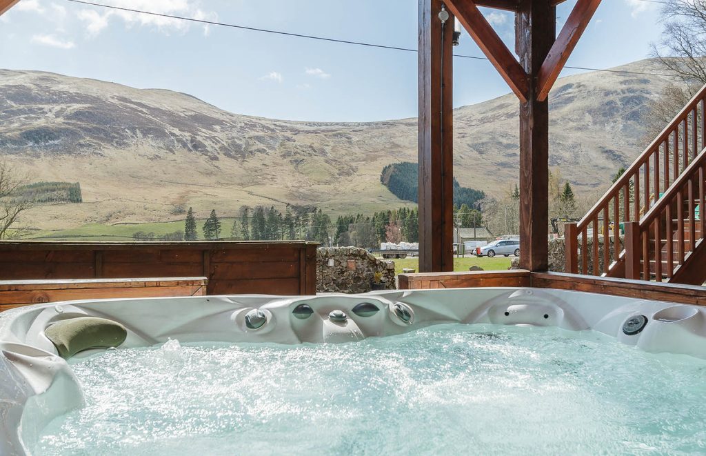 A hot tub with a stunning view on a Glen Lodge at Glen Clova Hotel and Lodges in Scotland