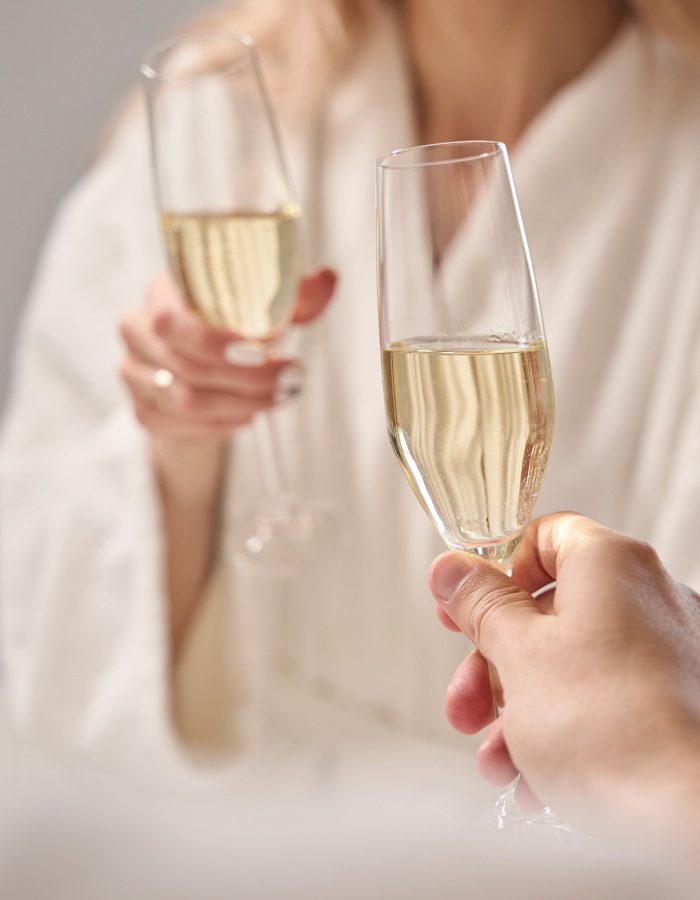 Couple in bathrobes enjoying a romantic break with glasses of champagne